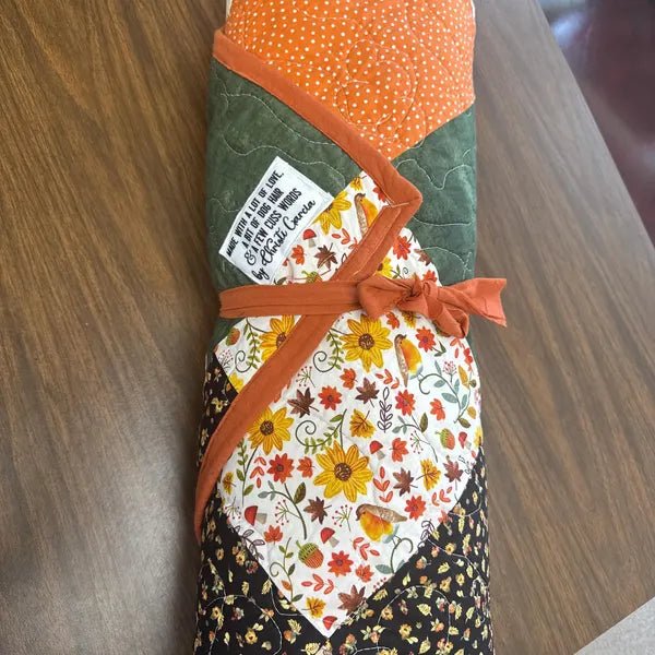 Funny quilt label sewn onto a quilt that reads “Made with a lot of love, a bit of dog hair and a few cuss words” personalized with maker name.