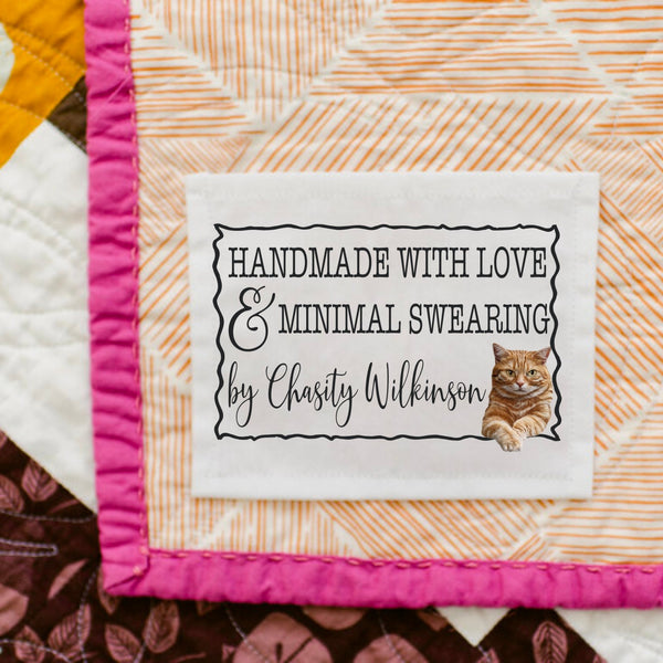 Funny handmade with love and minimal swearing quilt label with smug cat illustration personalized with maker name sewn onto quilt