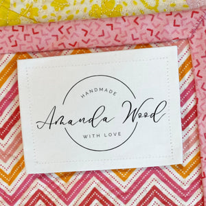 Personalized modern logo style quilt label with maker name handmade with love sewn onto quilt